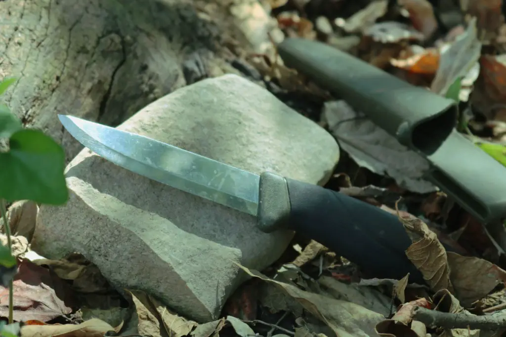 a dull knife next to a stone.