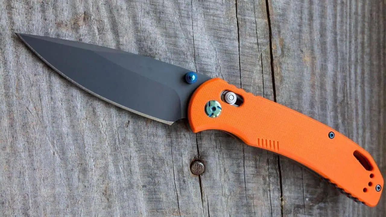 photo of an orange benchmade knife laying on a plank of wood