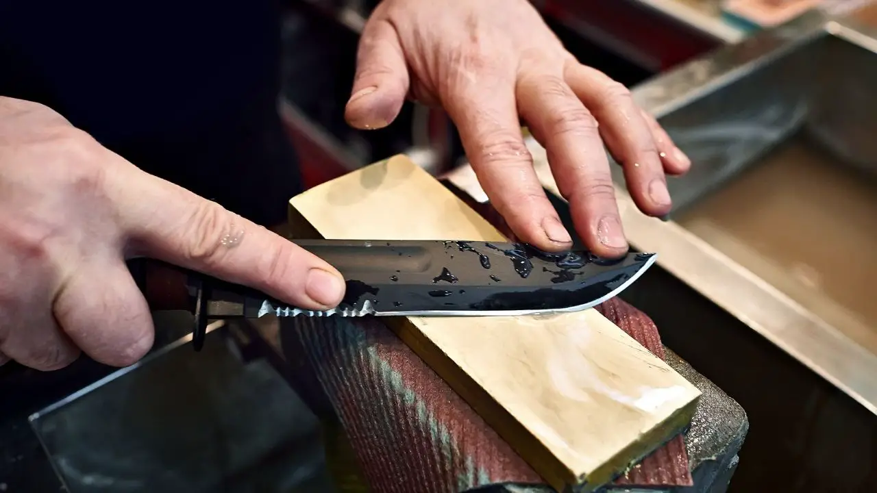 photo of a person sharpening a fixed blade knife