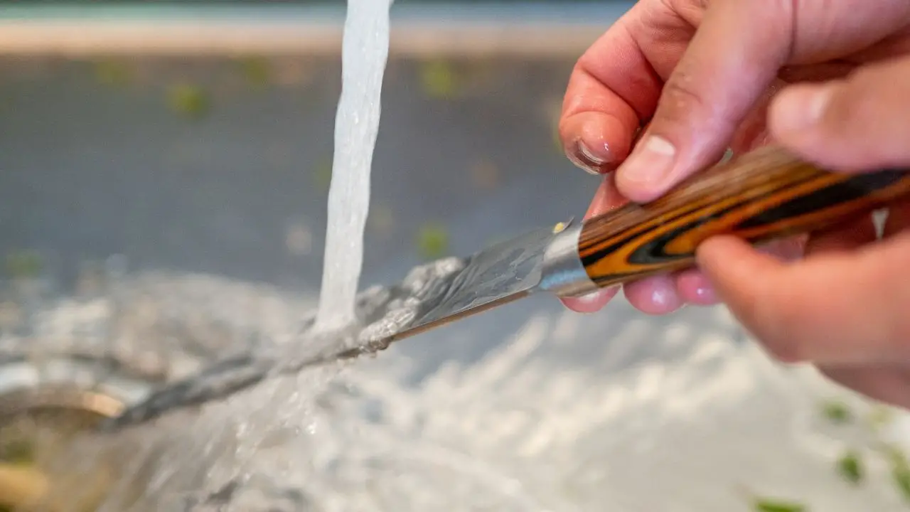 photo of a stream of water running onto a knife blade