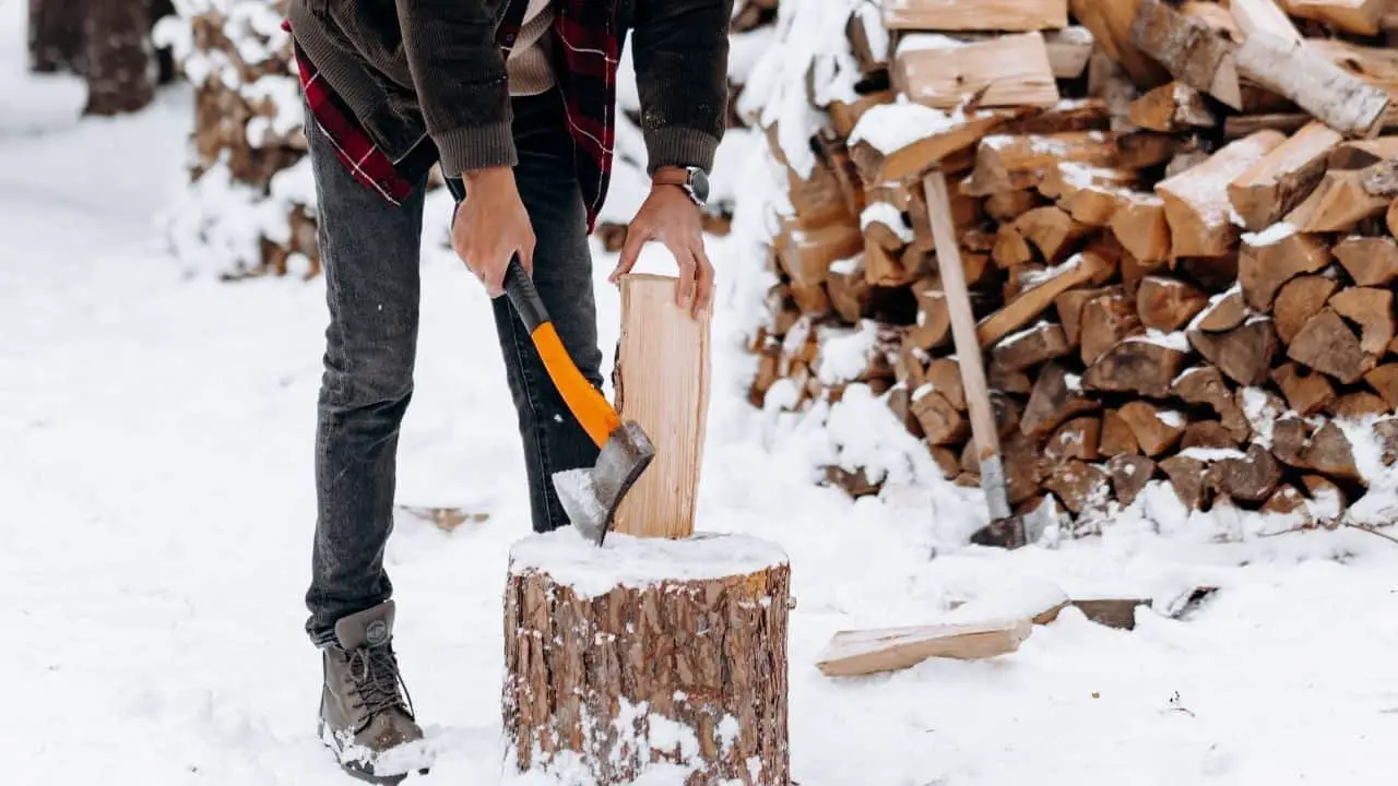 photo of a man getting ready to chop a log with an orange hatchet