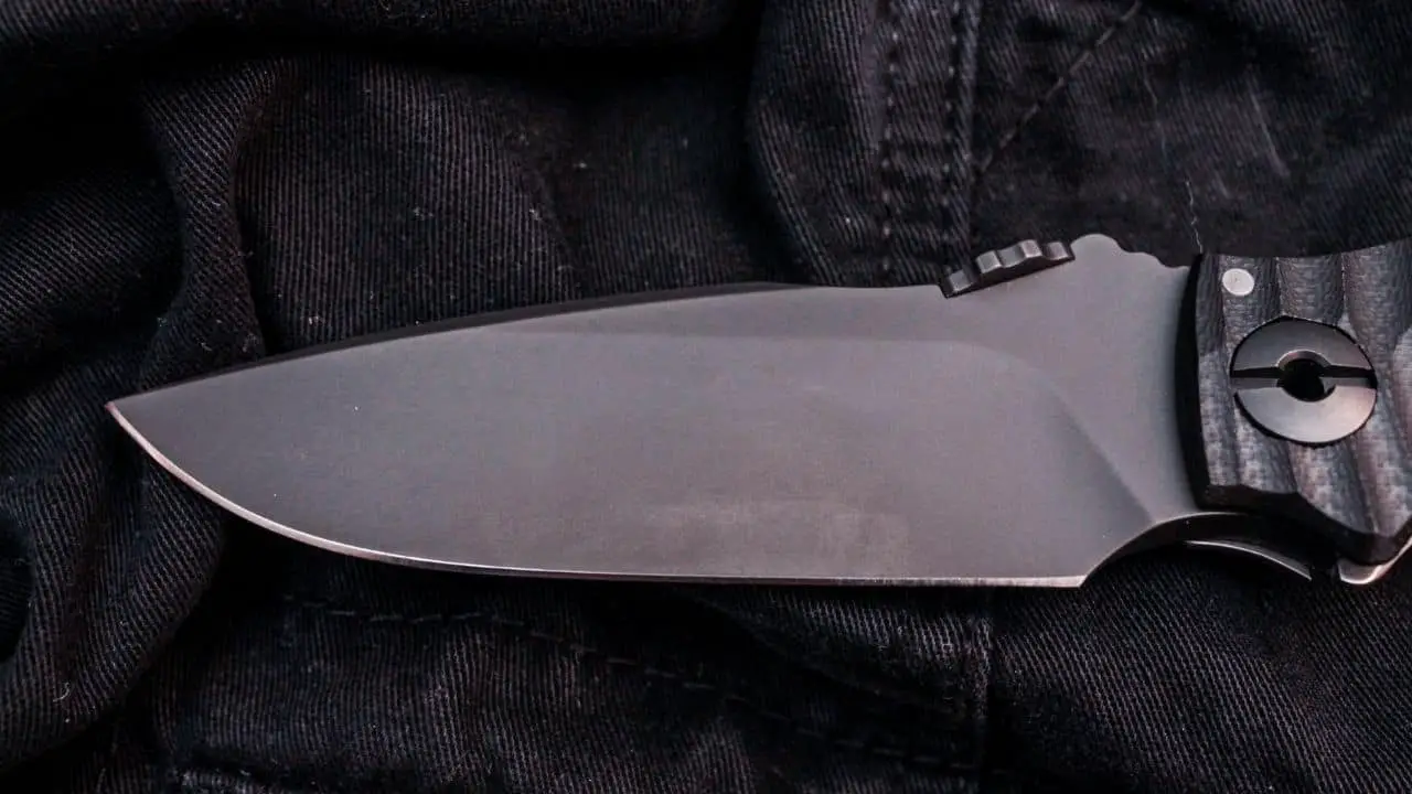 photo of a titanium knife blade on a jean fabric background