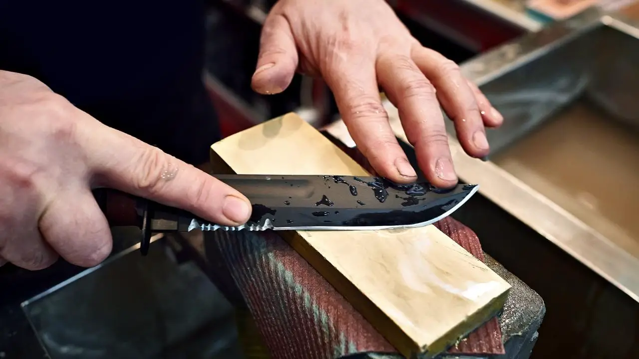 photo of person sharpening knife on whetstone